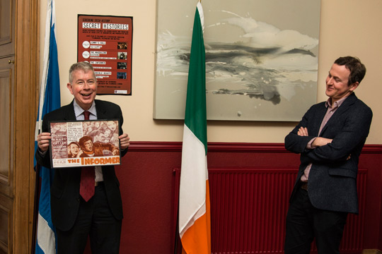 CG Bourne displays a poster from the third film in the series, The Informer