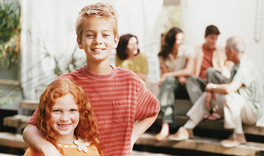 brother and sister standing in a garden