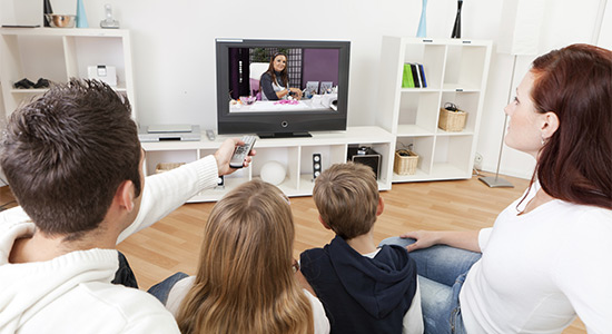 Family watching TV at home