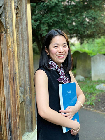 Portrait photograph of Japanese pianist Riho Akagi carrying her piano music book.