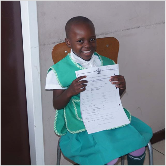 A girl proudly displays her new identity document