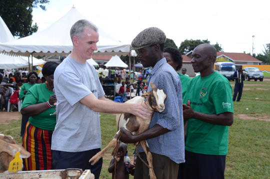 Ambassador Cronin handing a goat to one of the community members